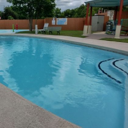 A large swimming pool with a bench in the background