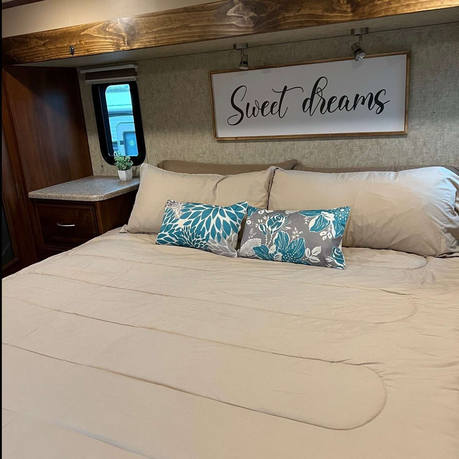 A bed with a sign above it that says sweet dreams