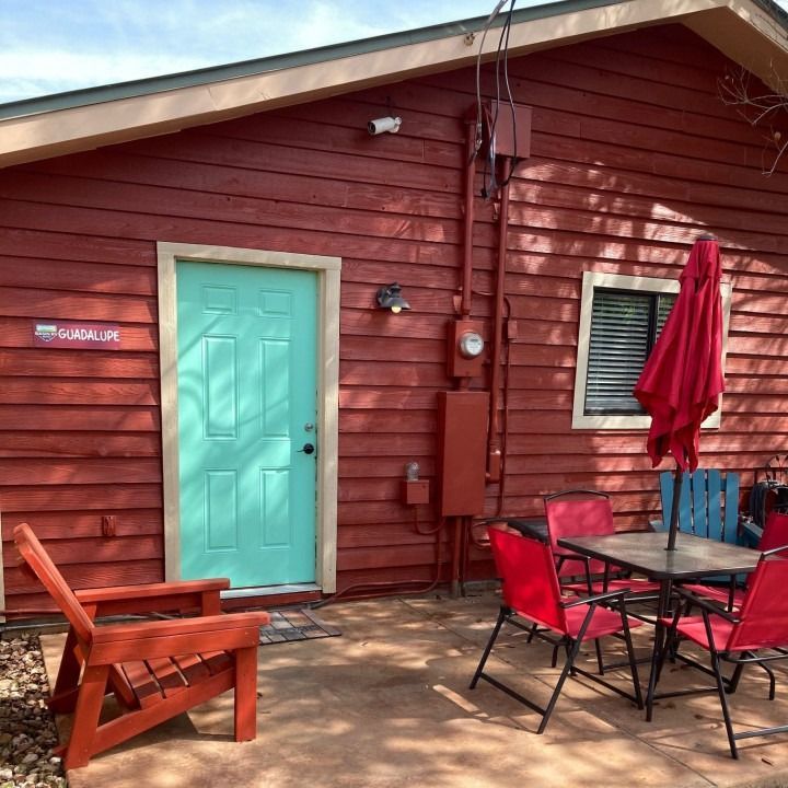 A red house with a blue door and a chair