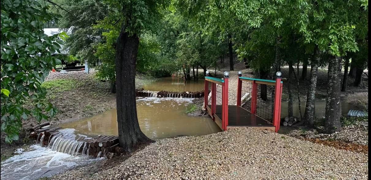 A red bridge over a flooded river in the woods.