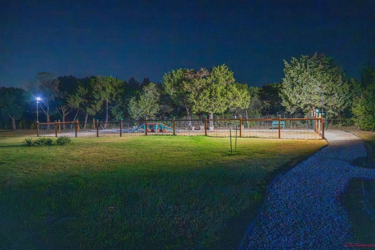 There is a fence in the middle of a field at night.