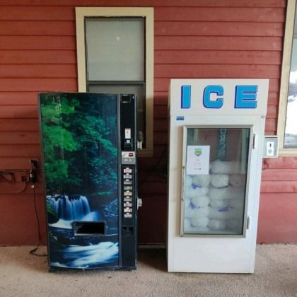 A vending machine with a waterfall design next to an ice machine