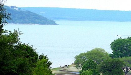 A large body of water surrounded by trees and mountains.