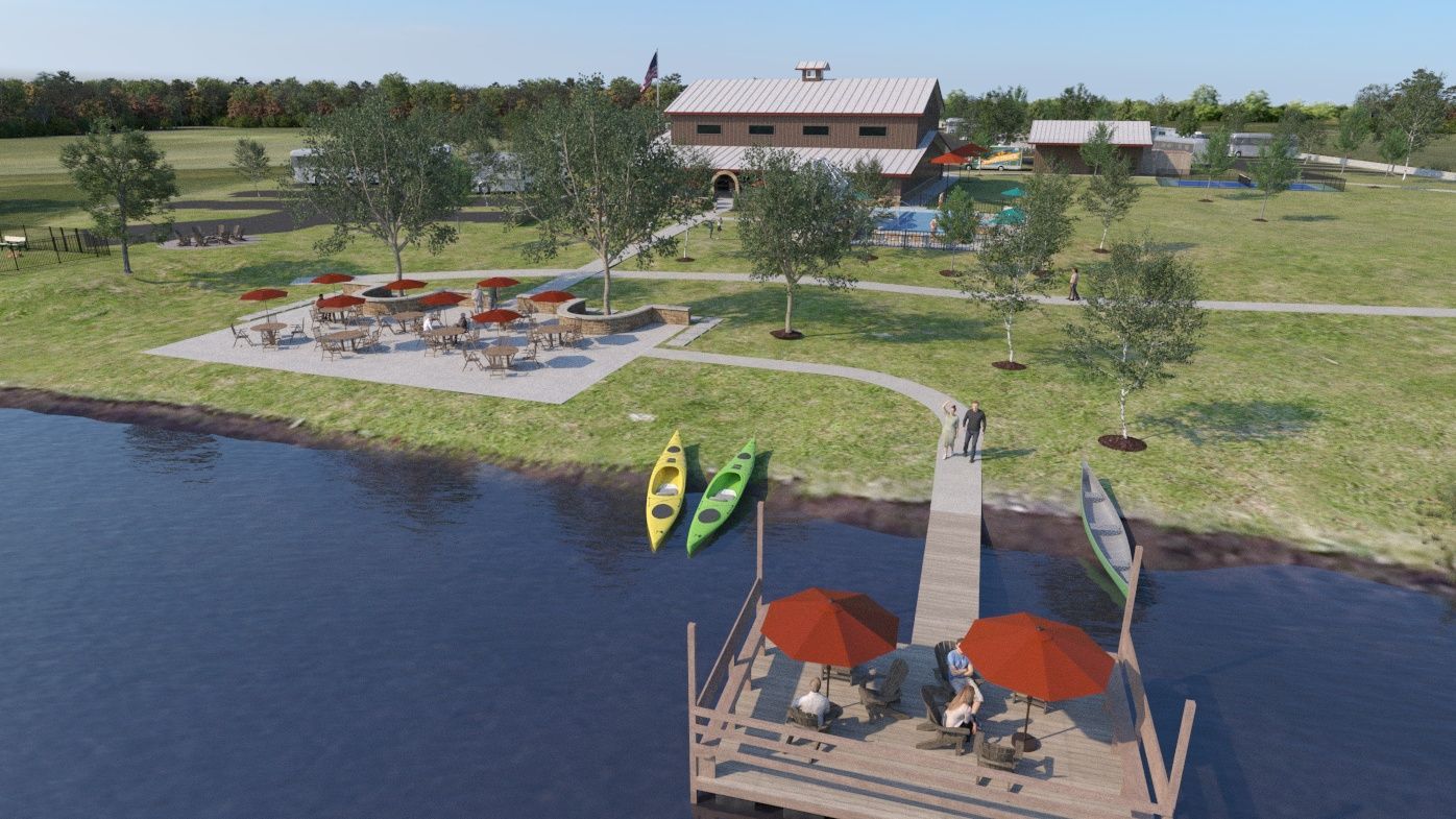 A statue of a moose is lit up at night.