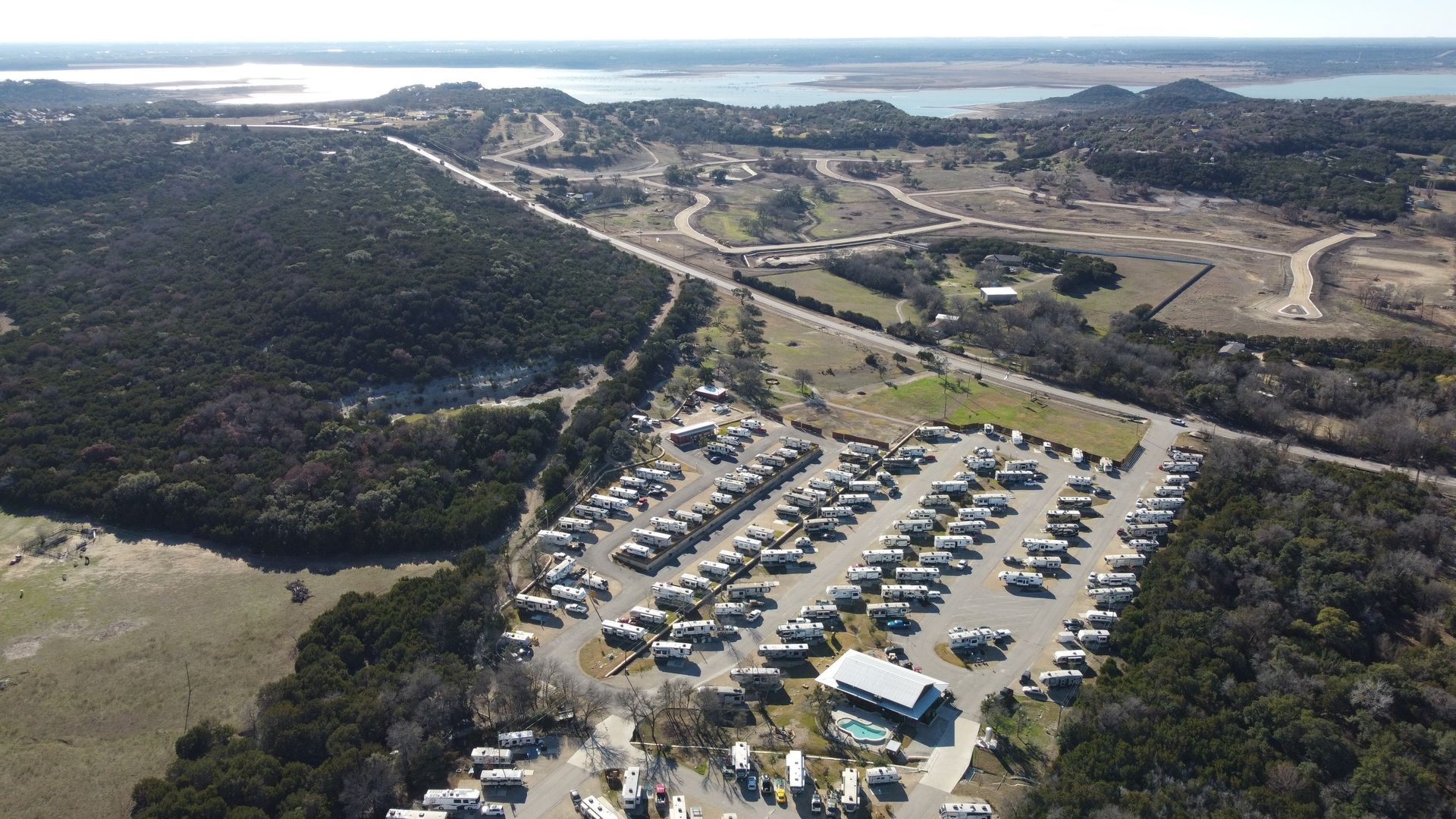 An aerial view of a rv park with a lake in the background.