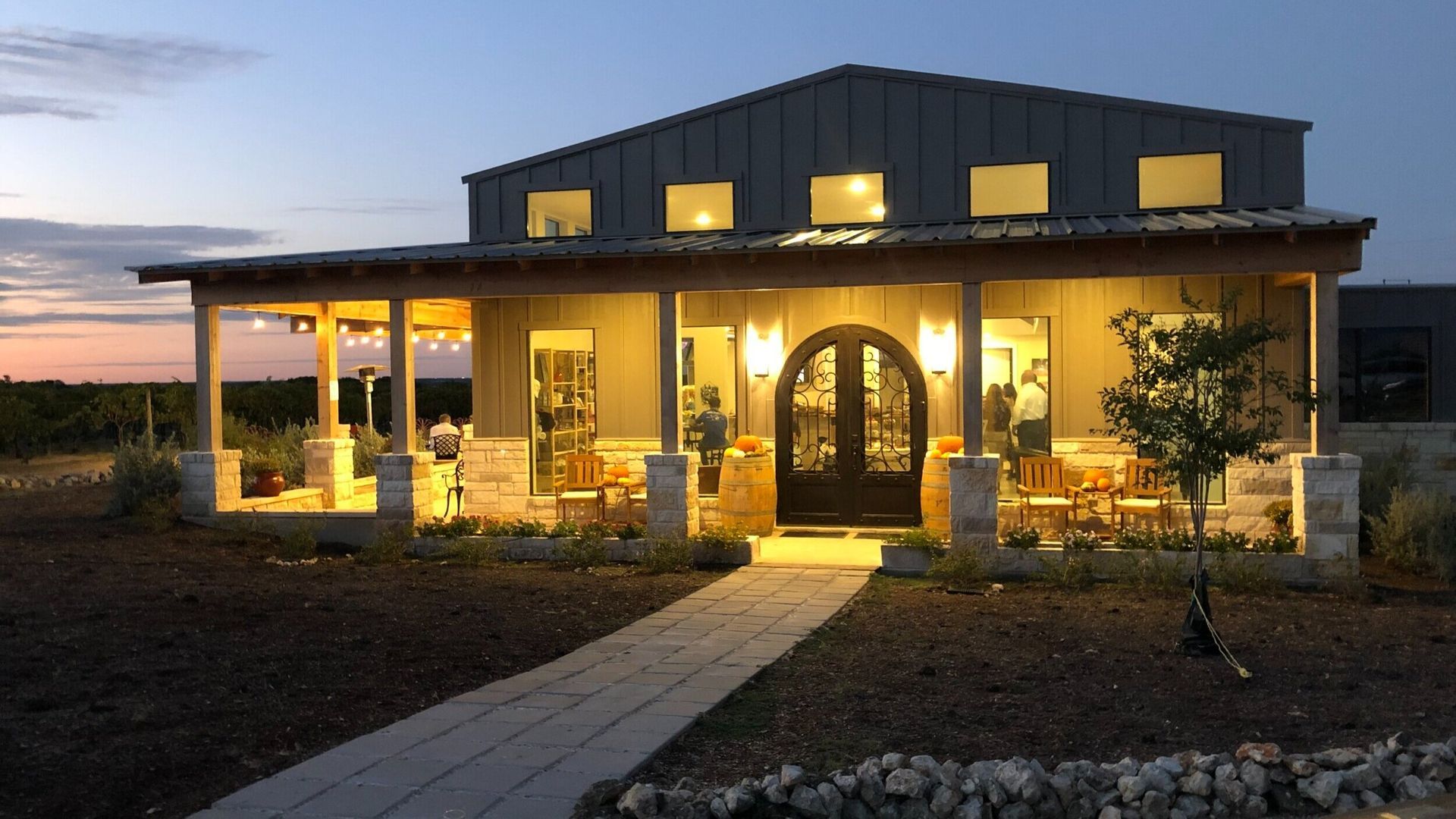 A large house with a walkway leading to it is lit up at night.