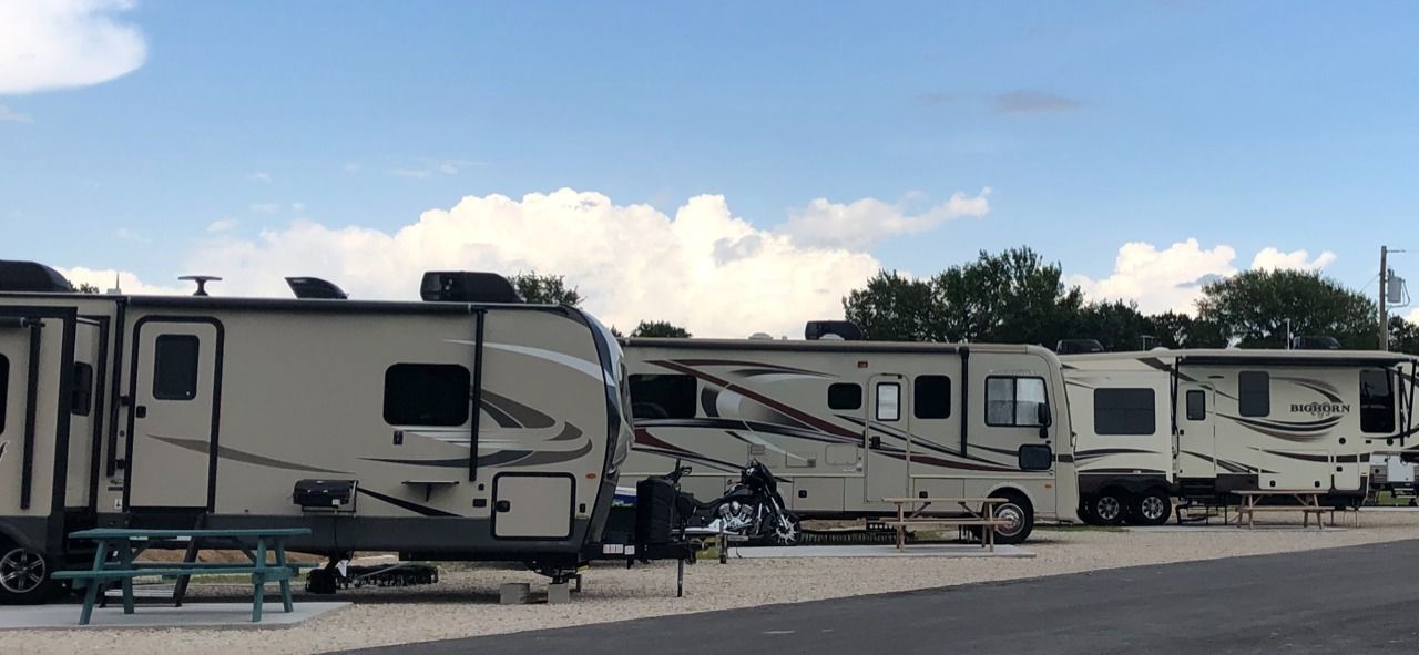 A row of rvs parked next to each other in a parking lot.