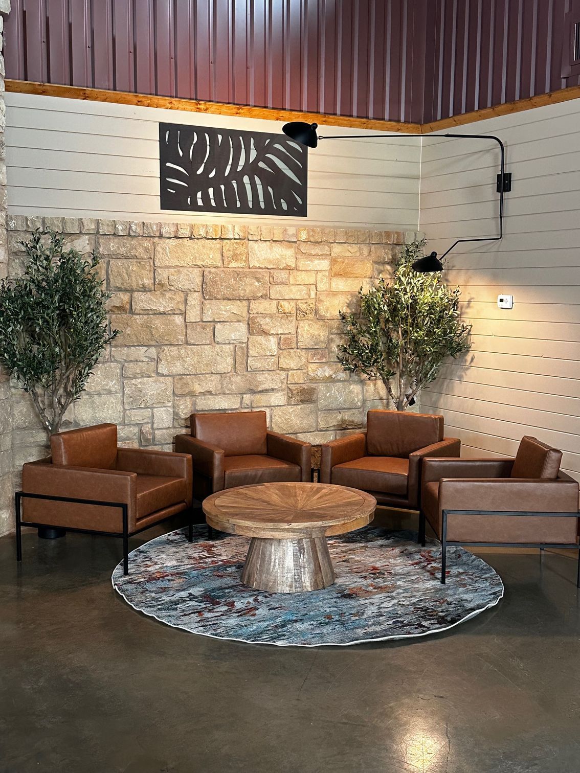 A cat is laying on a stone wall in a garden