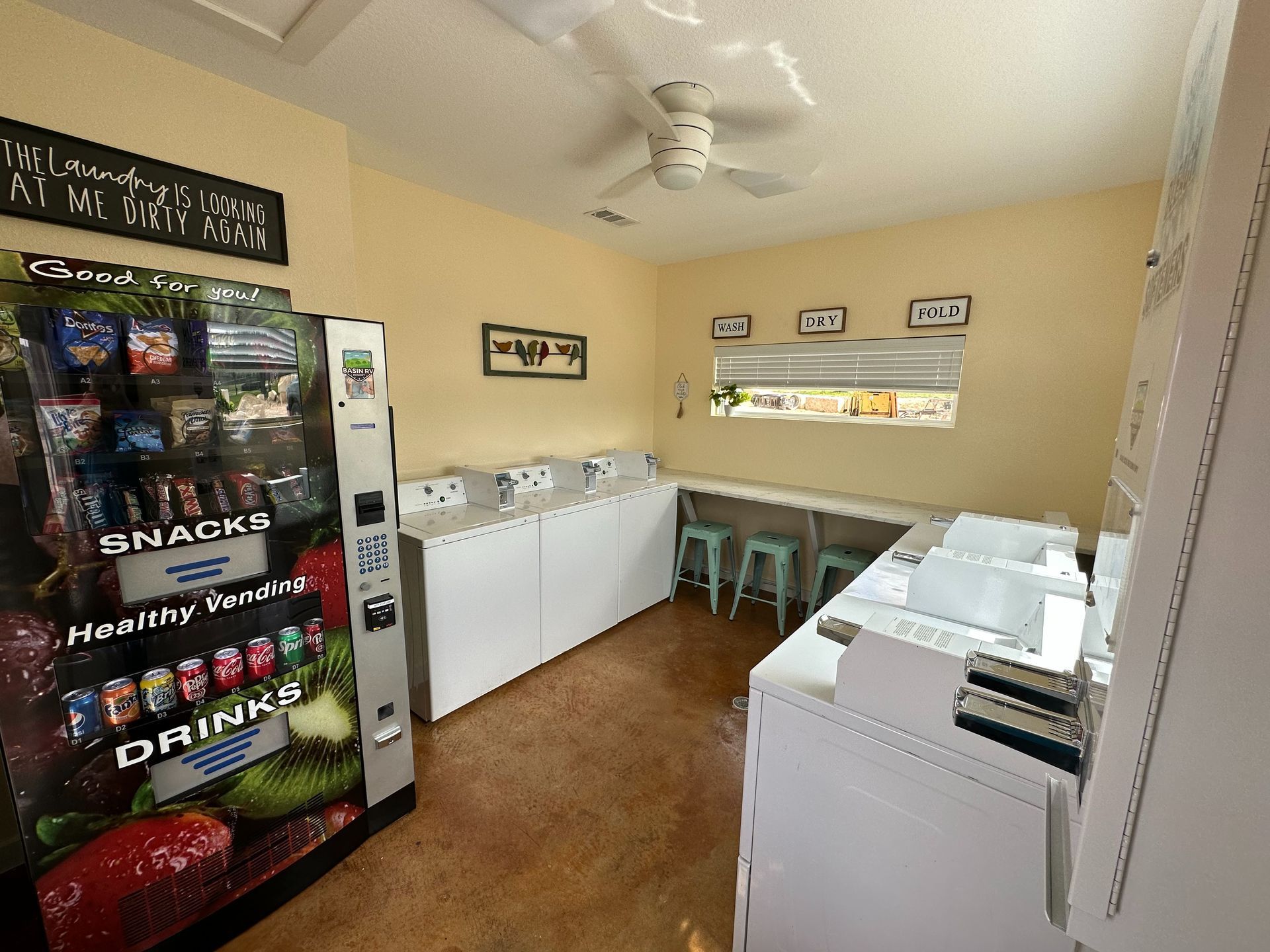 A laundromat with a vending machine that sells snacks and drinks