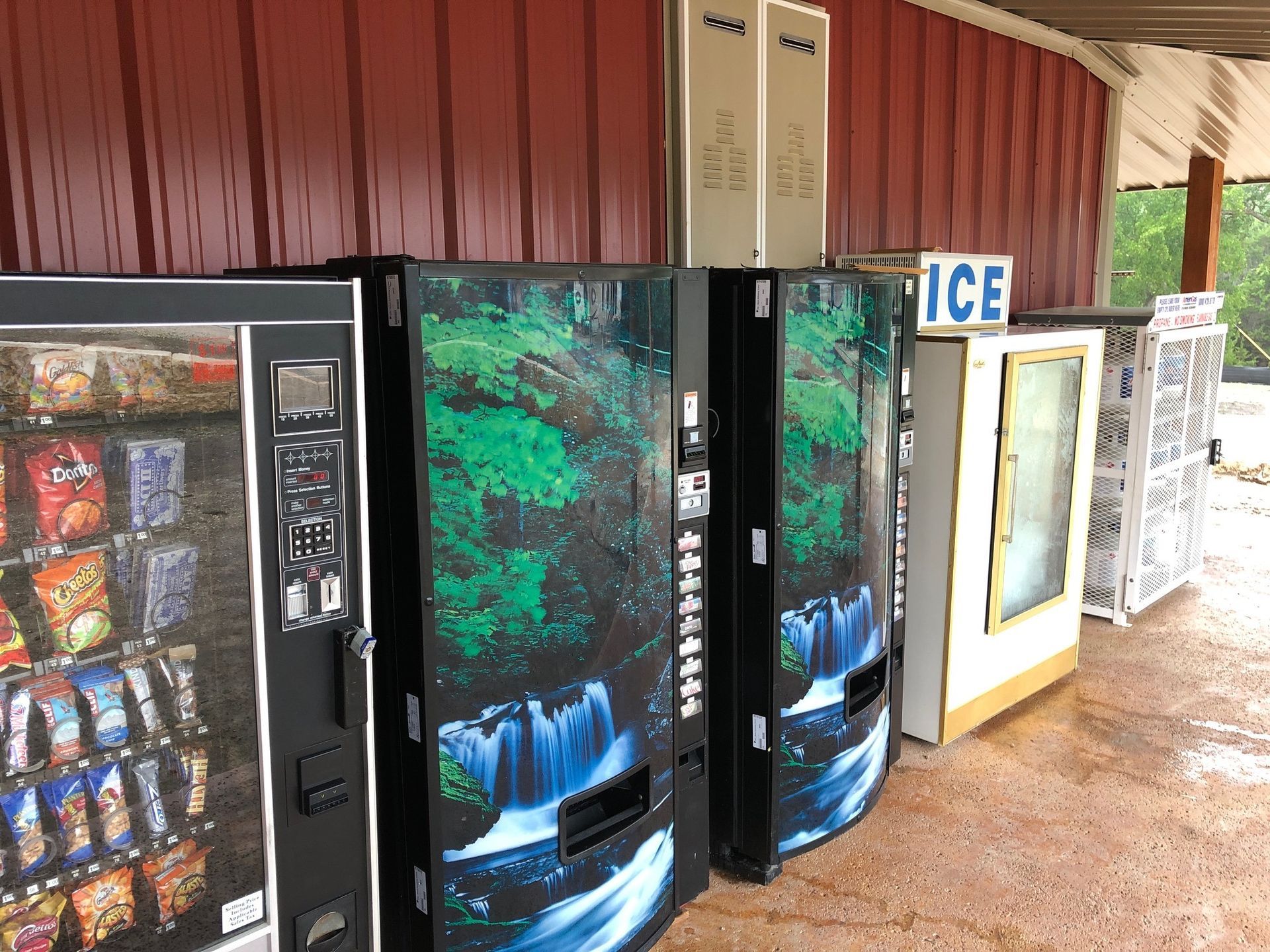A row of vending machines are lined up in front of a building.