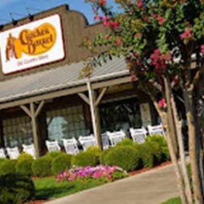 A chicken bagel restaurant with flowers in front of it