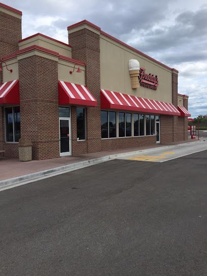 A brick building with a red awning that says ' freddy 's ' on it