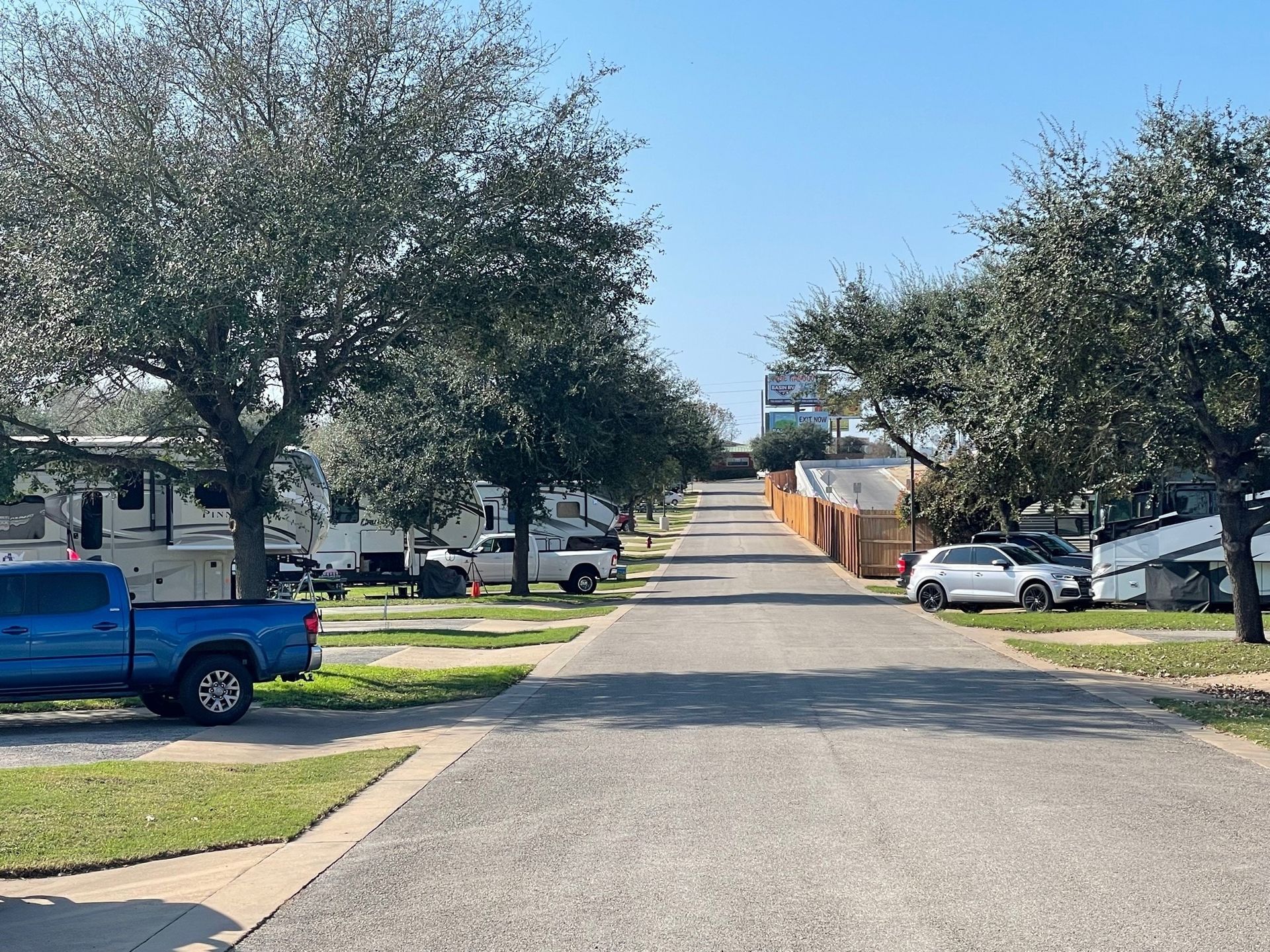 A blue truck is parked on the side of the road in a residential area.
