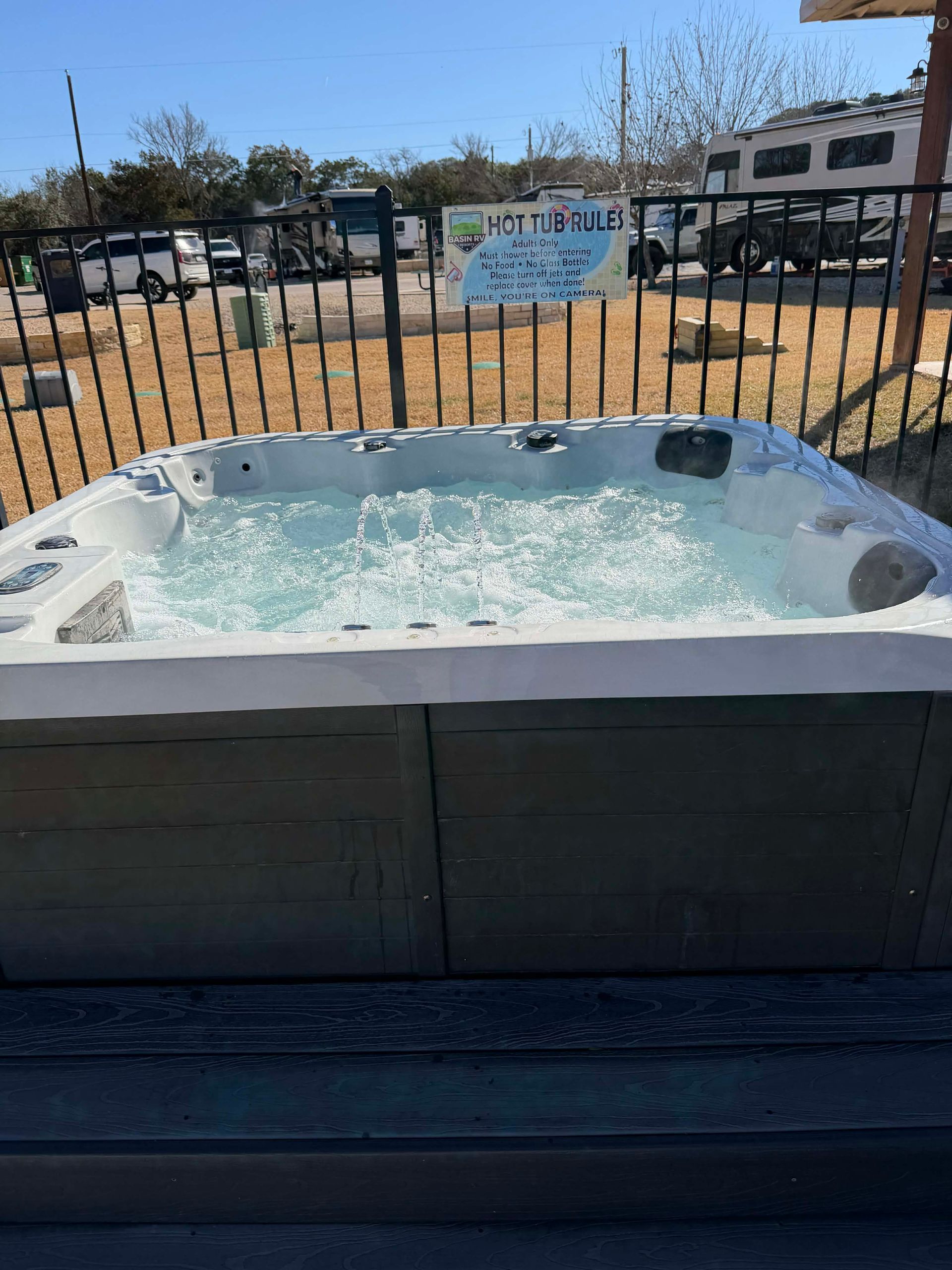 A hot tub is sitting on a patio next to a pool.