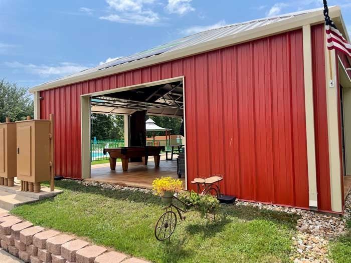 A red barn with a pool table and a bicycle in front of it.