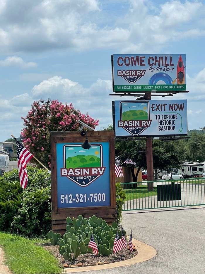 A sign for a rv park with a camera on top of it.