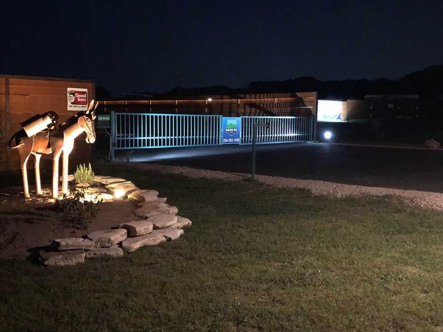 A statue of a moose is lit up at night.