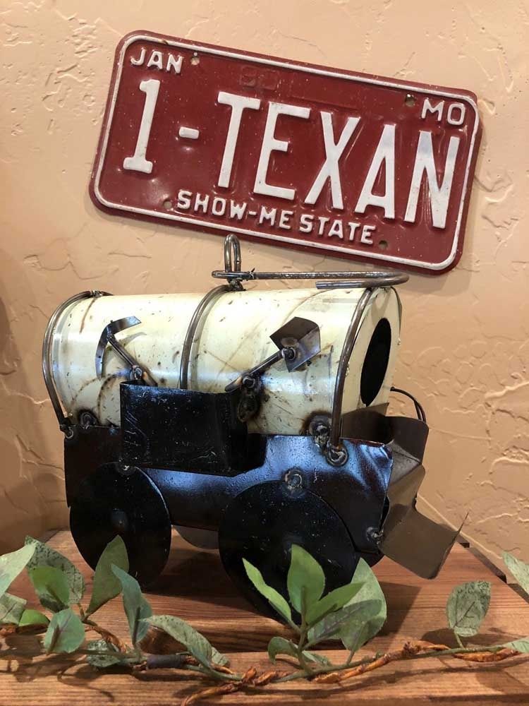 A toy truck with a license plate that says 1-texan is sitting on a wooden table.