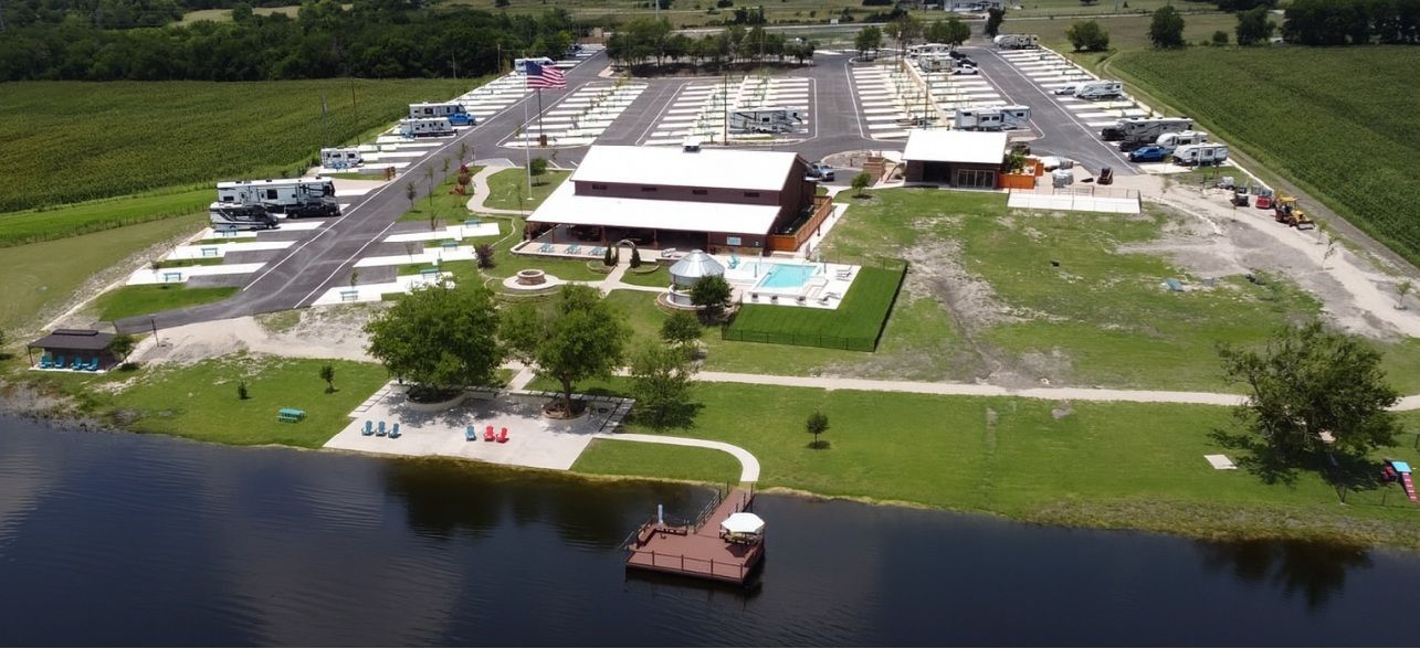 A large barn with a covered porch is lit up at night.