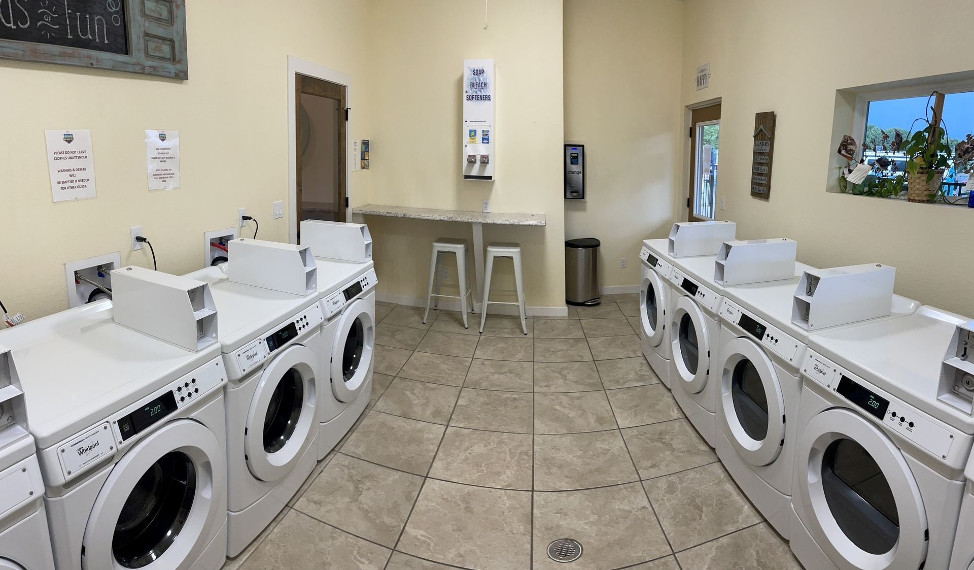 A laundromat filled with lots of washing machines and dryers.