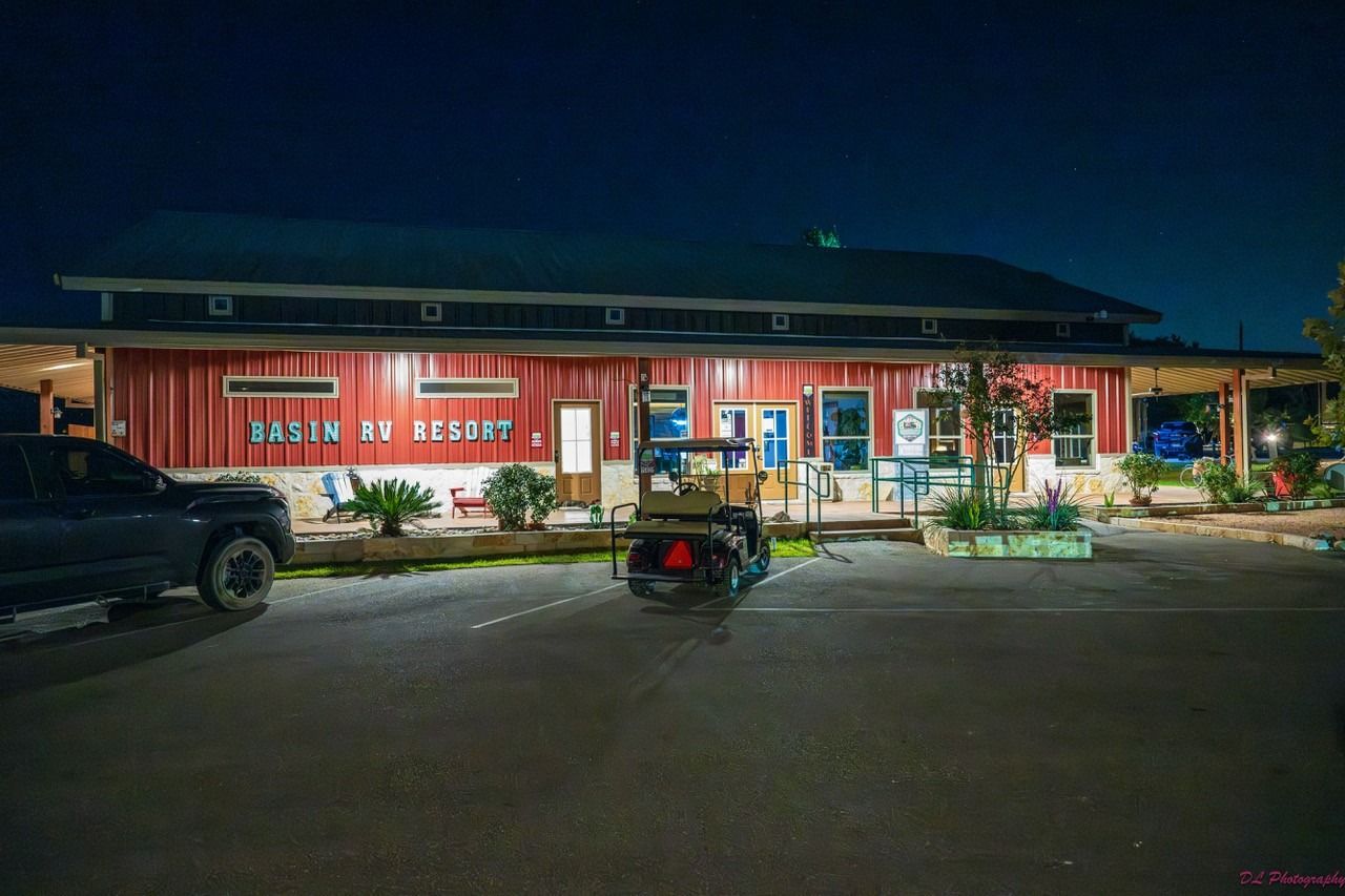 A truck is parked in front of a building at night.
