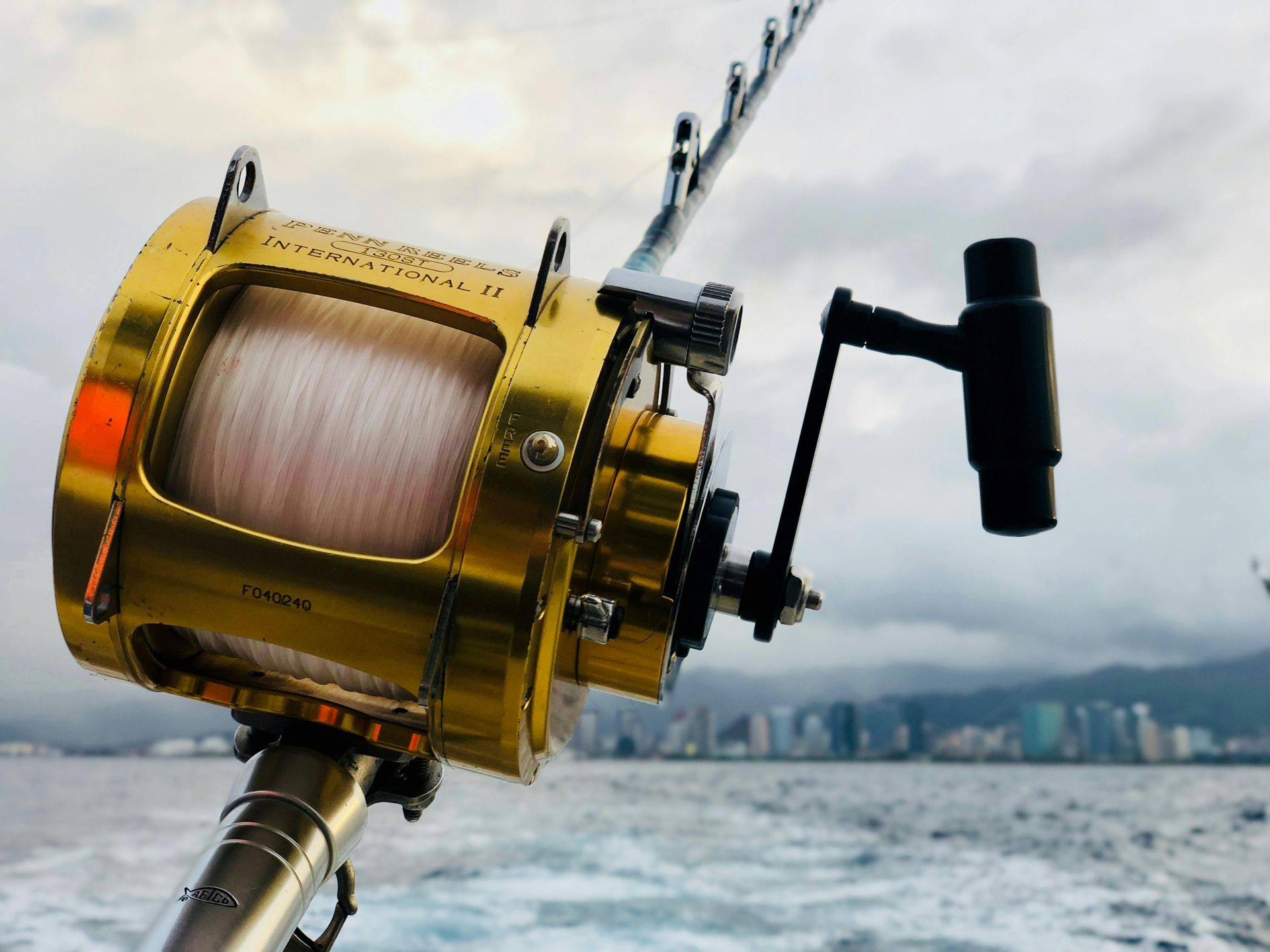 A close up of a fishing reel on a boat in the ocean.