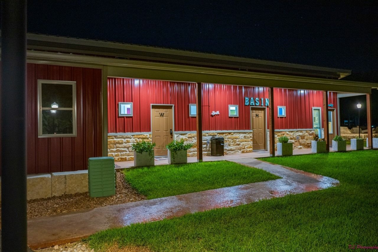 A large red barn with a walkway leading to it at night.