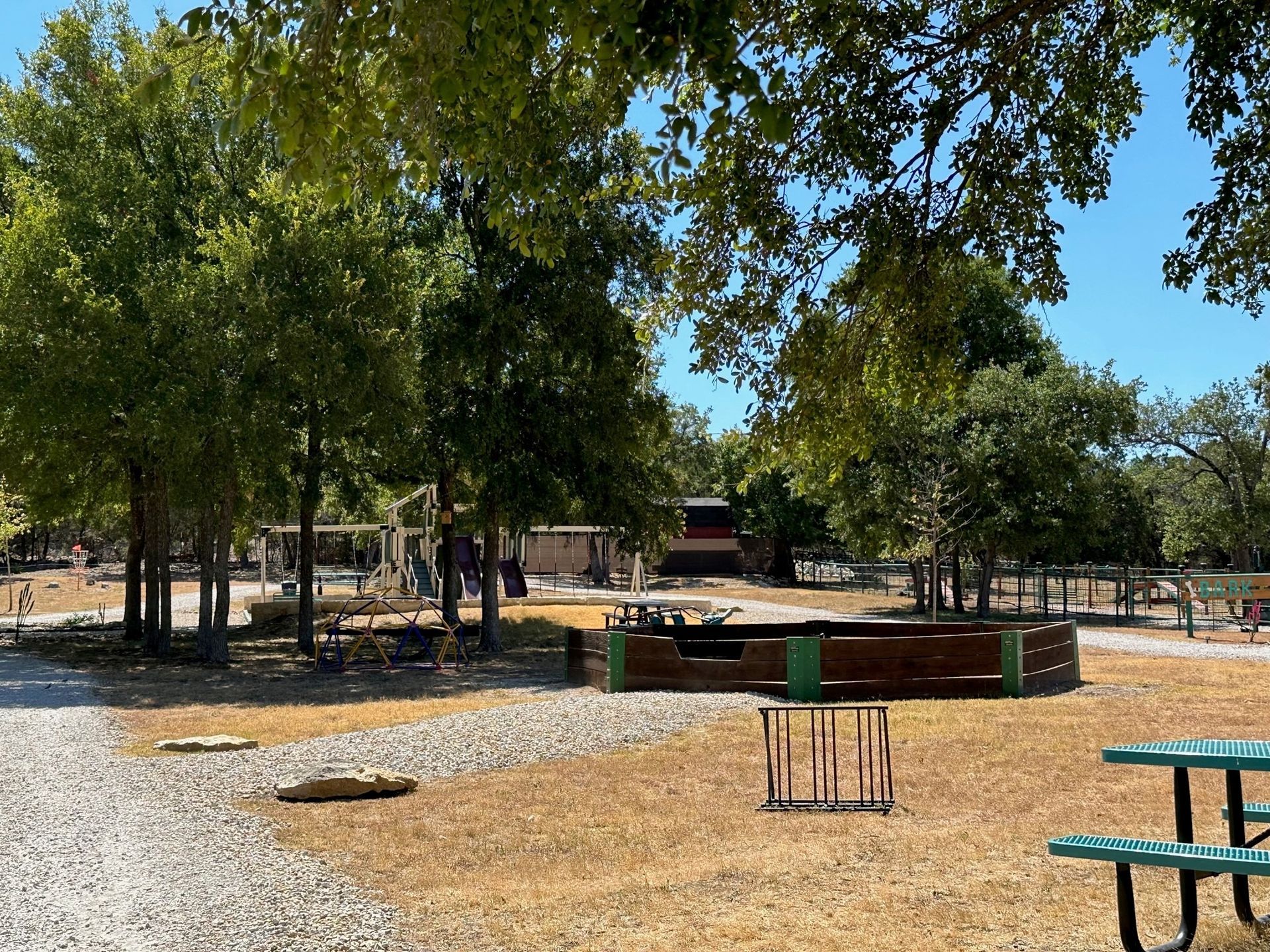 A picnic table is sitting in the middle of a park surrounded by trees.