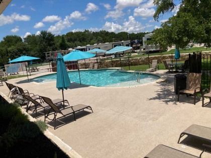 A large swimming pool surrounded by chairs and umbrellas.