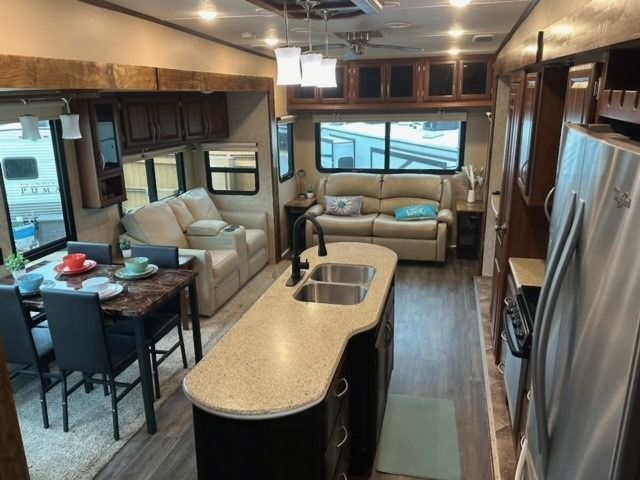 The inside of a rv with a living room and kitchen