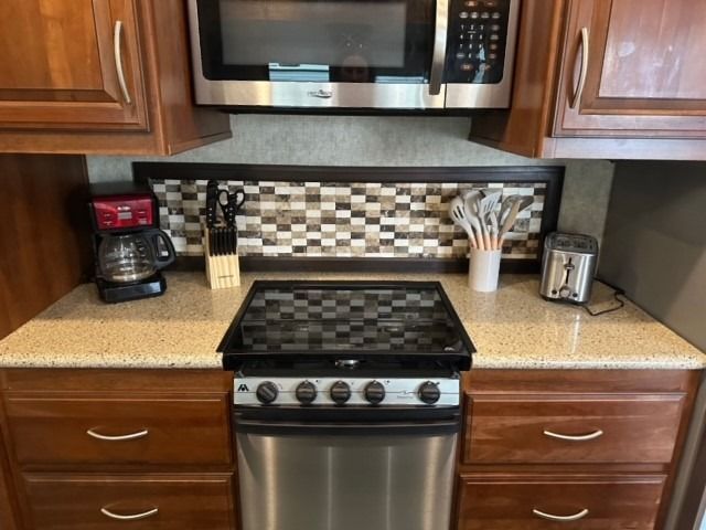 A kitchen with a stove a microwave and a coffee maker