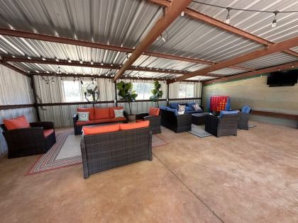 A patio with a lot of furniture and a television.