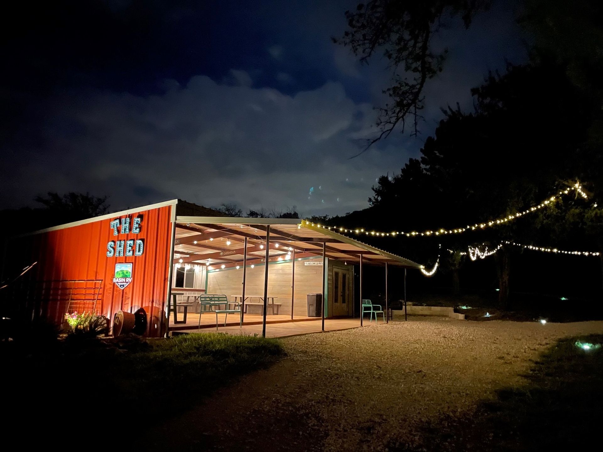 A red building with the word shed on it is lit up at night
