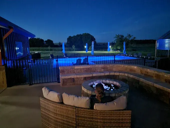 A patio with chairs and a ladder in front of a red building.