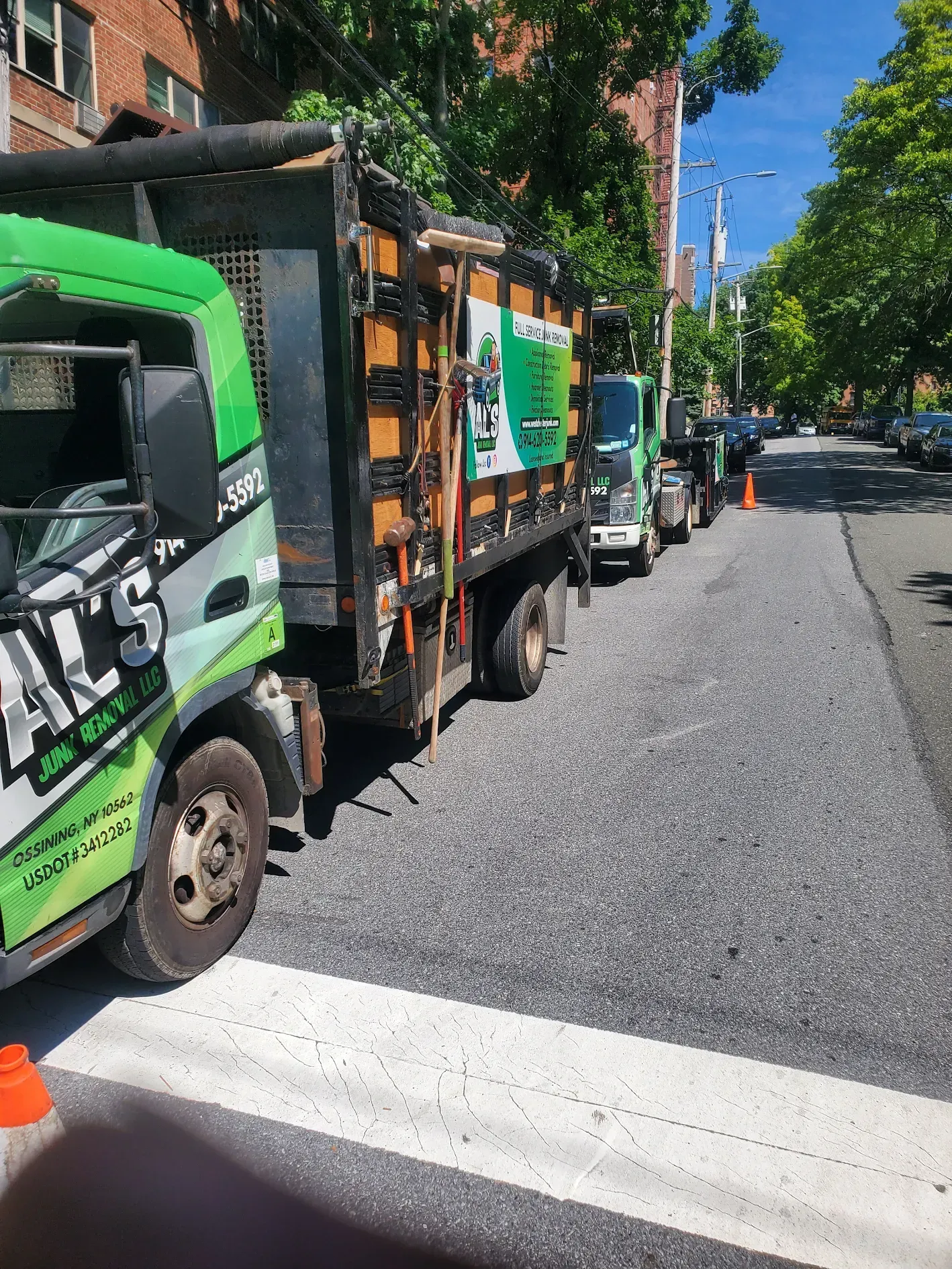 A row of dump trucks are parked on the side of the road.