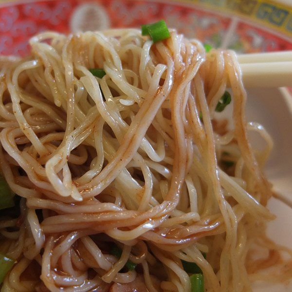 A close up of a bowl of noodles with chopsticks