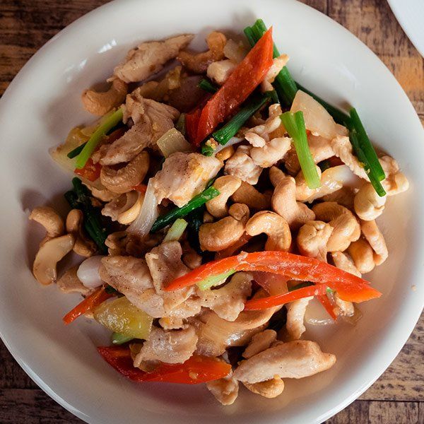 A white plate topped with chicken and vegetables