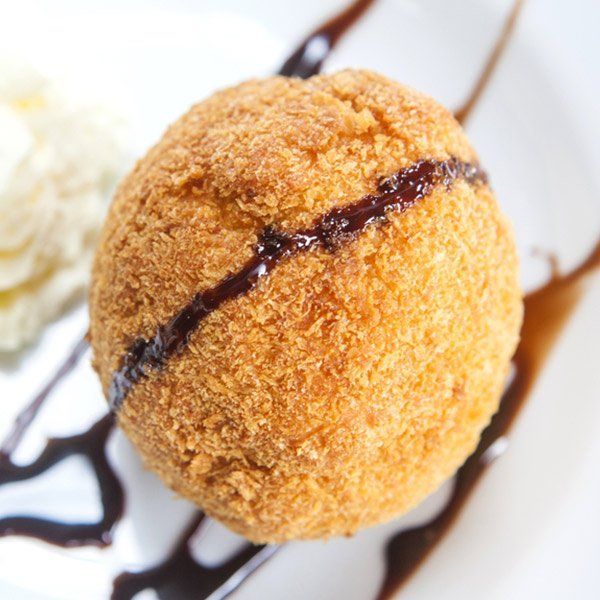 A fried ice cream ball with chocolate sauce on a white plate