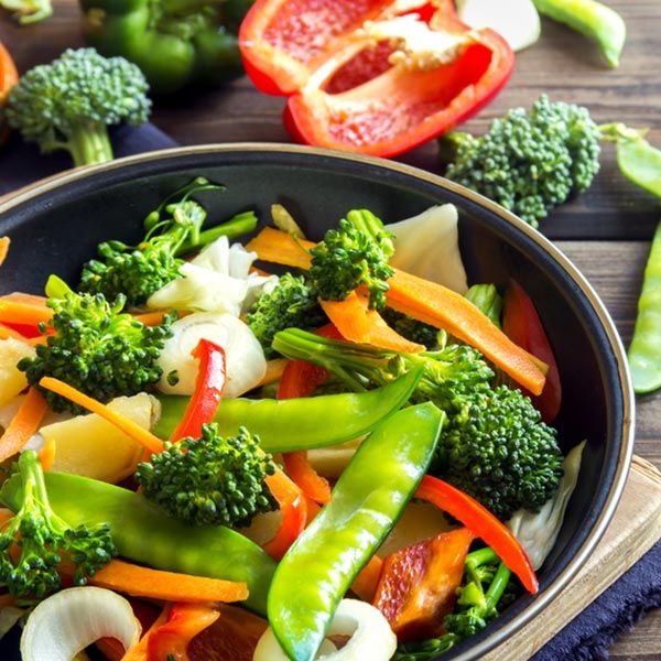 A close up of a bowl of vegetables on a table.
