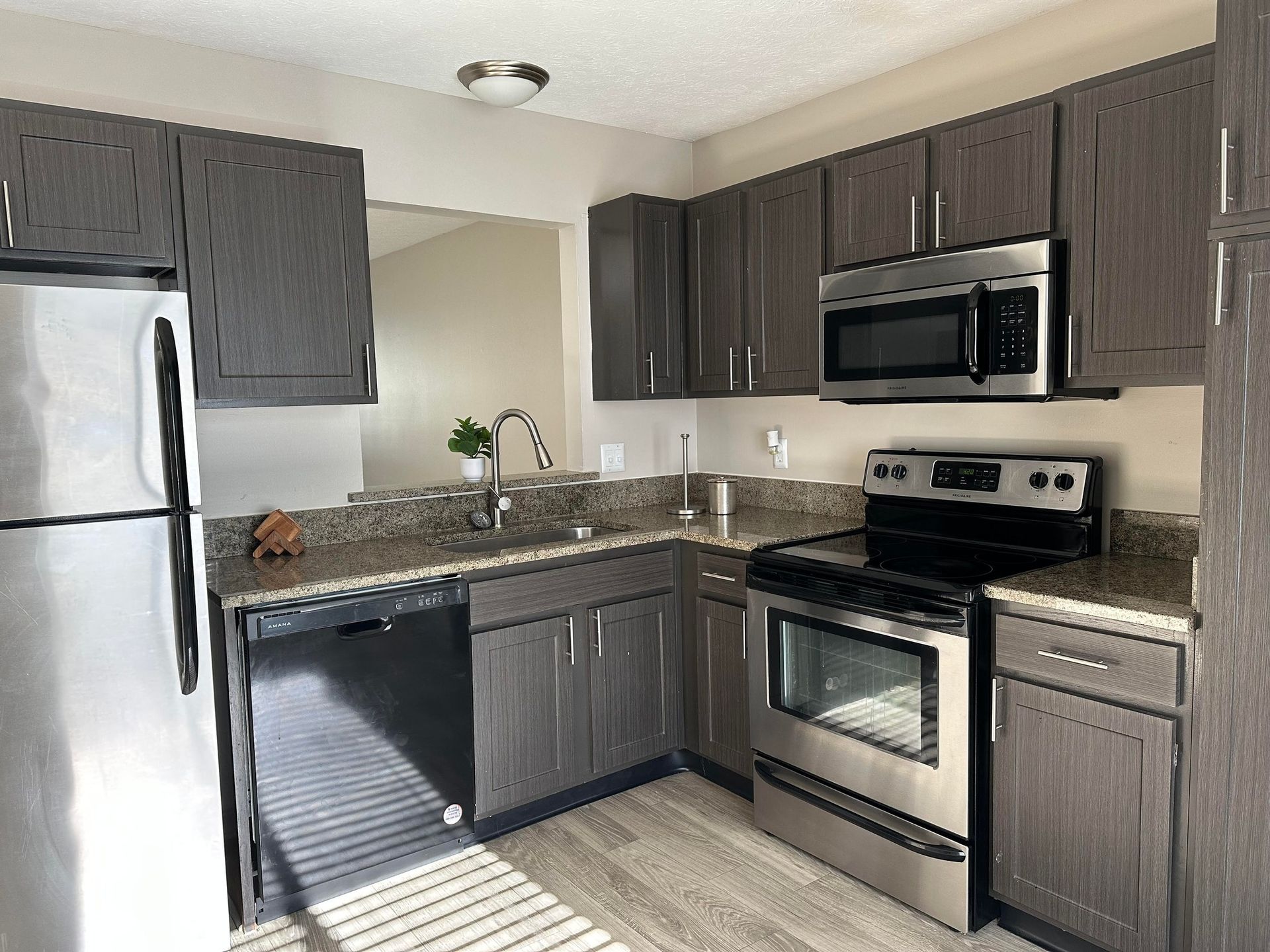 A kitchen with stainless steel appliances and gray cabinets