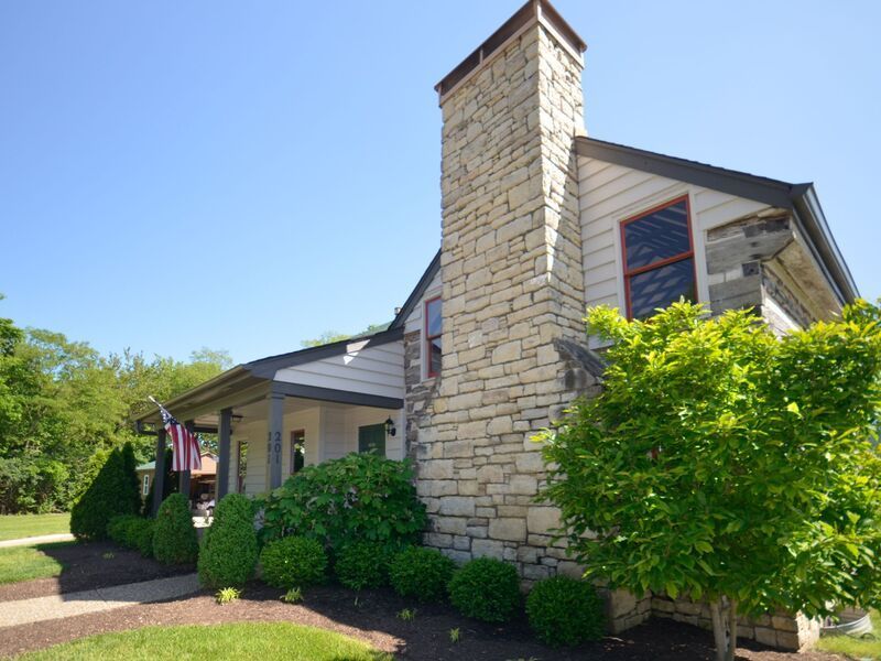 A large stone chimney is on the side of a house