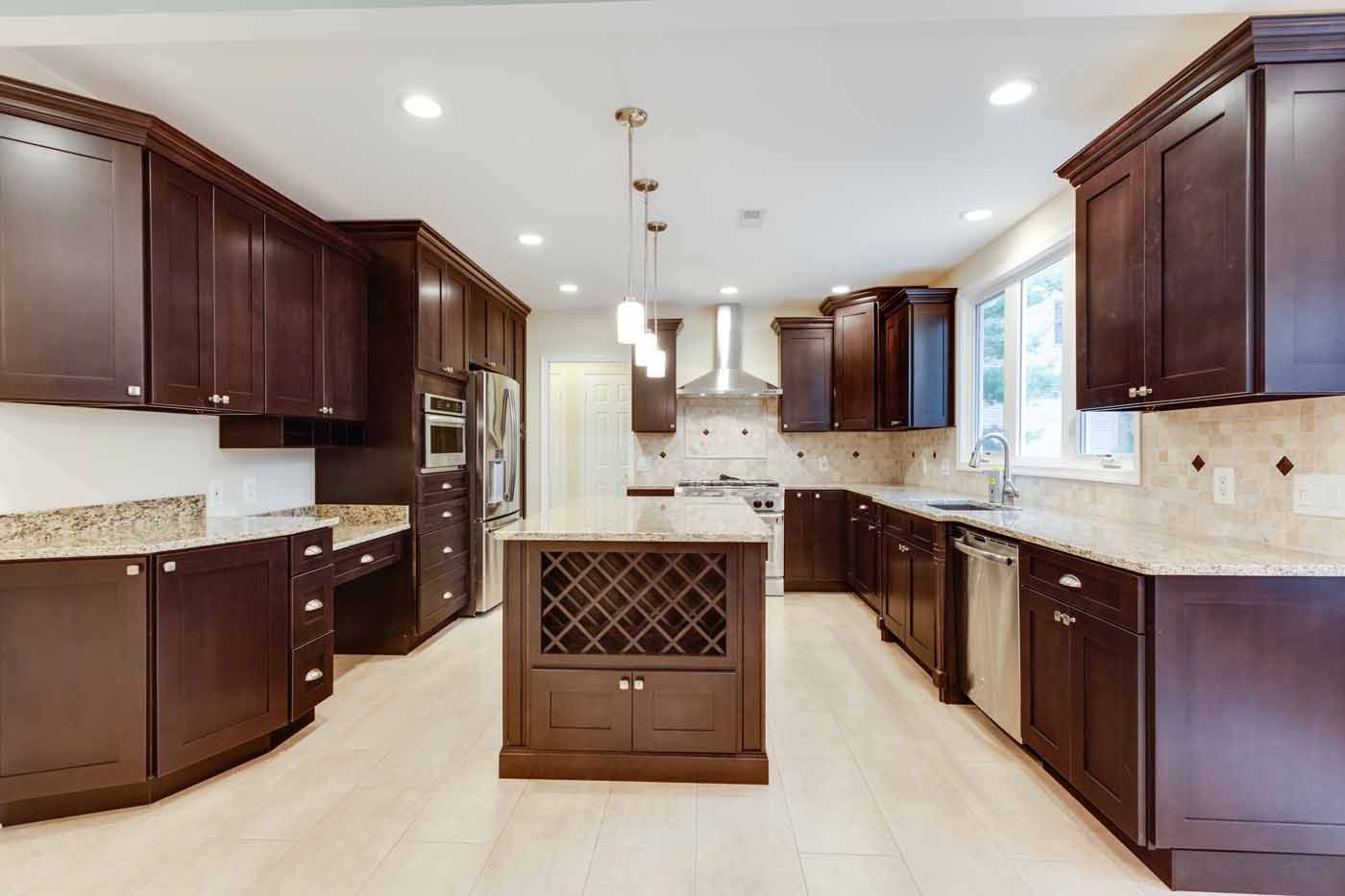 Spacious kitchen with dark brown cabinets, granite countertops, and a central island with a wine rack.