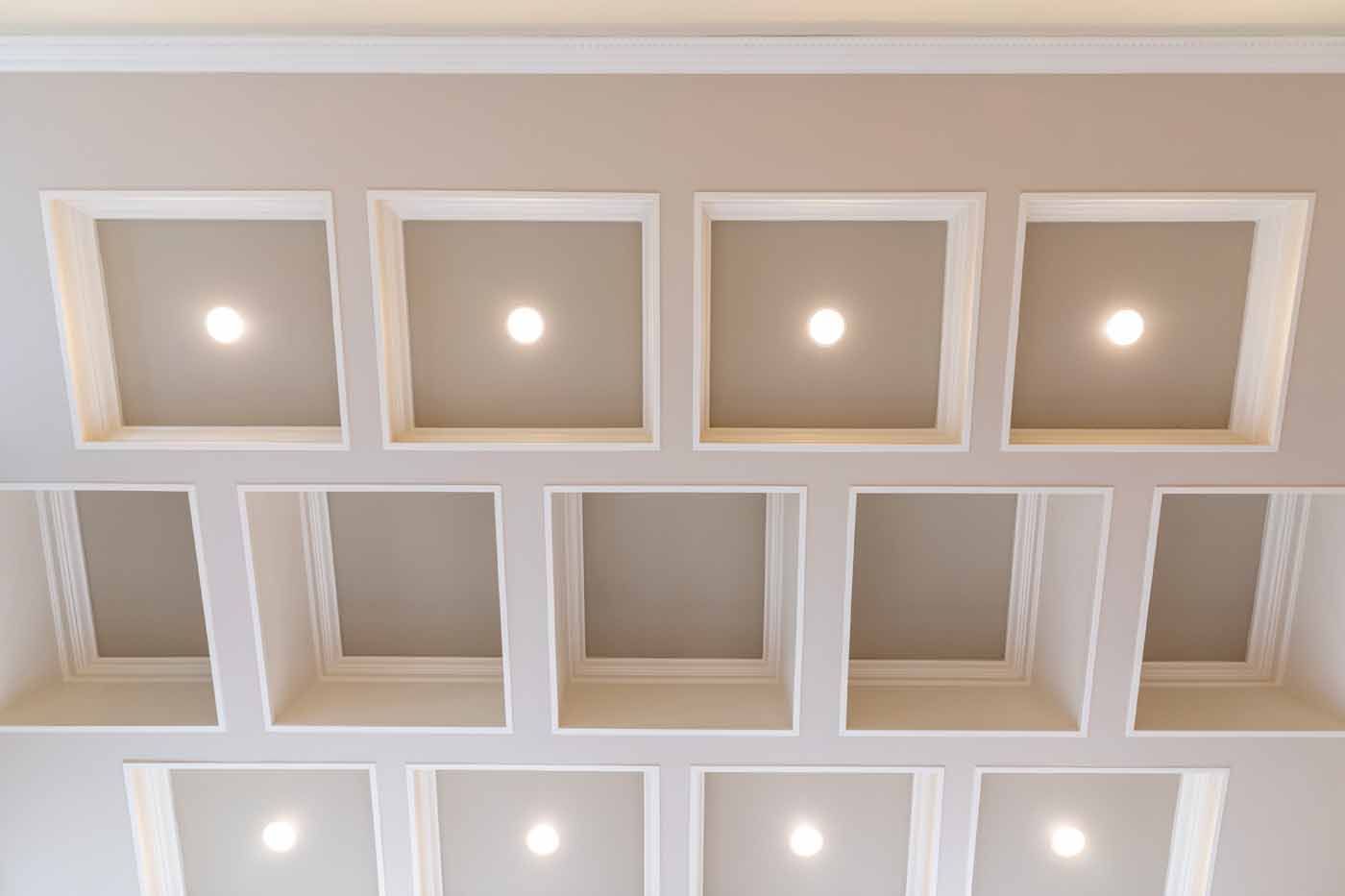 Ceiling with recessed square lighting fixtures, white with lit bulbs.