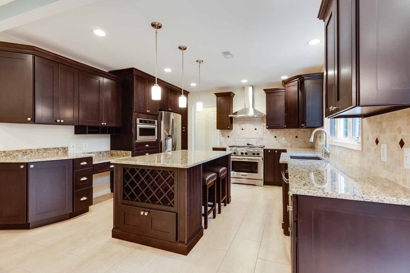 Spacious kitchen with dark wood cabinets, granite countertops, and a central island with wine storage.