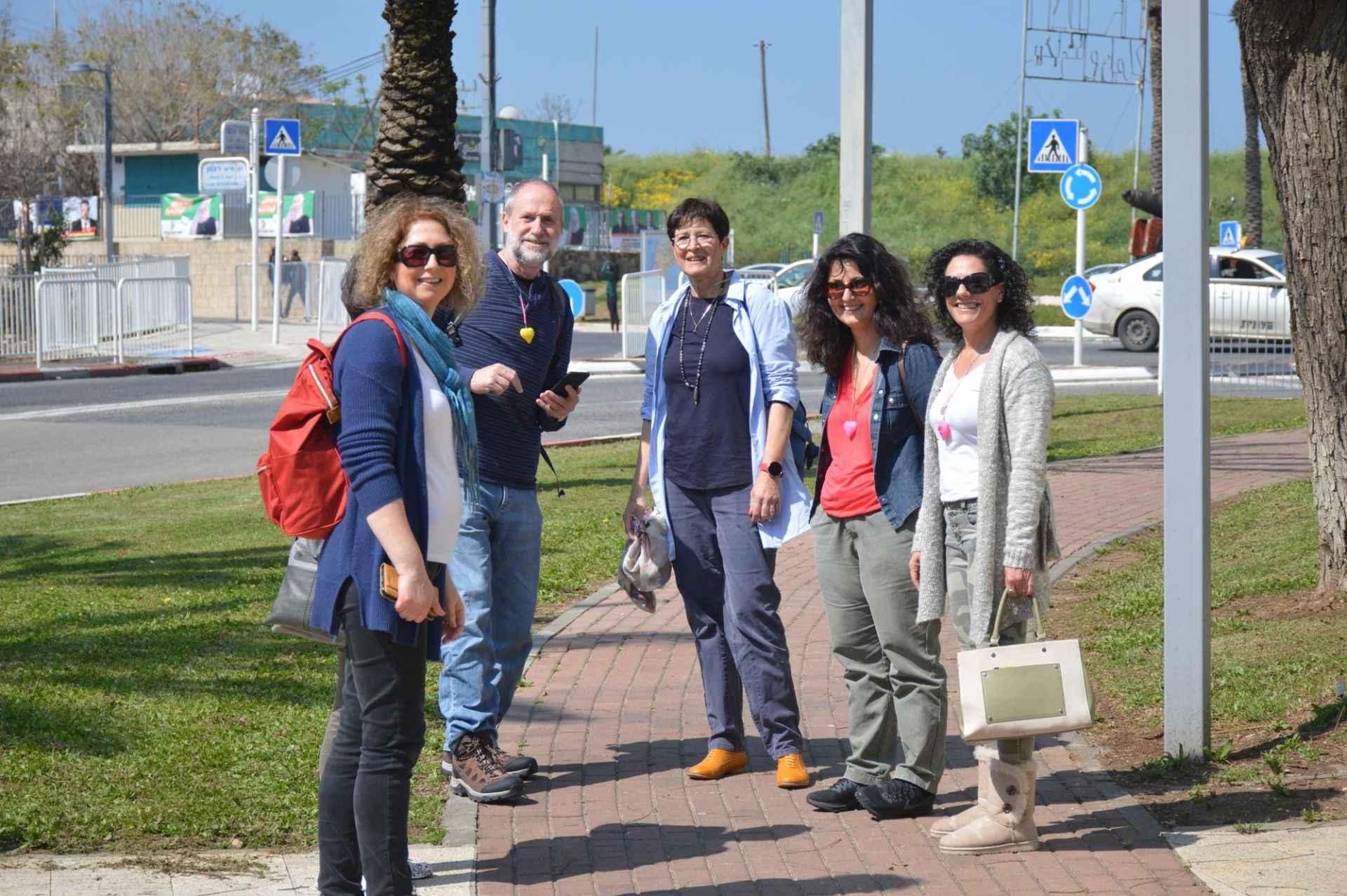 קבוצה של אנשים עומדים זה ליד זה על מדרכה.