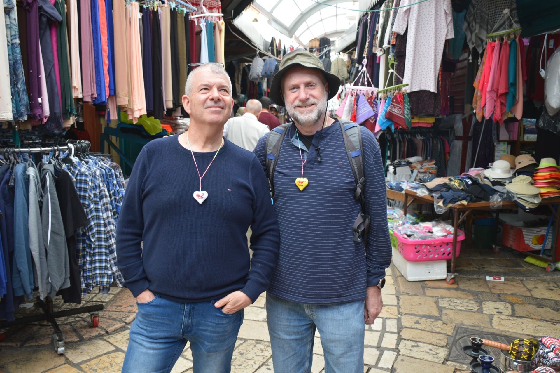 שני גברים עומדים זה ליד זה מול חנות בגדים.