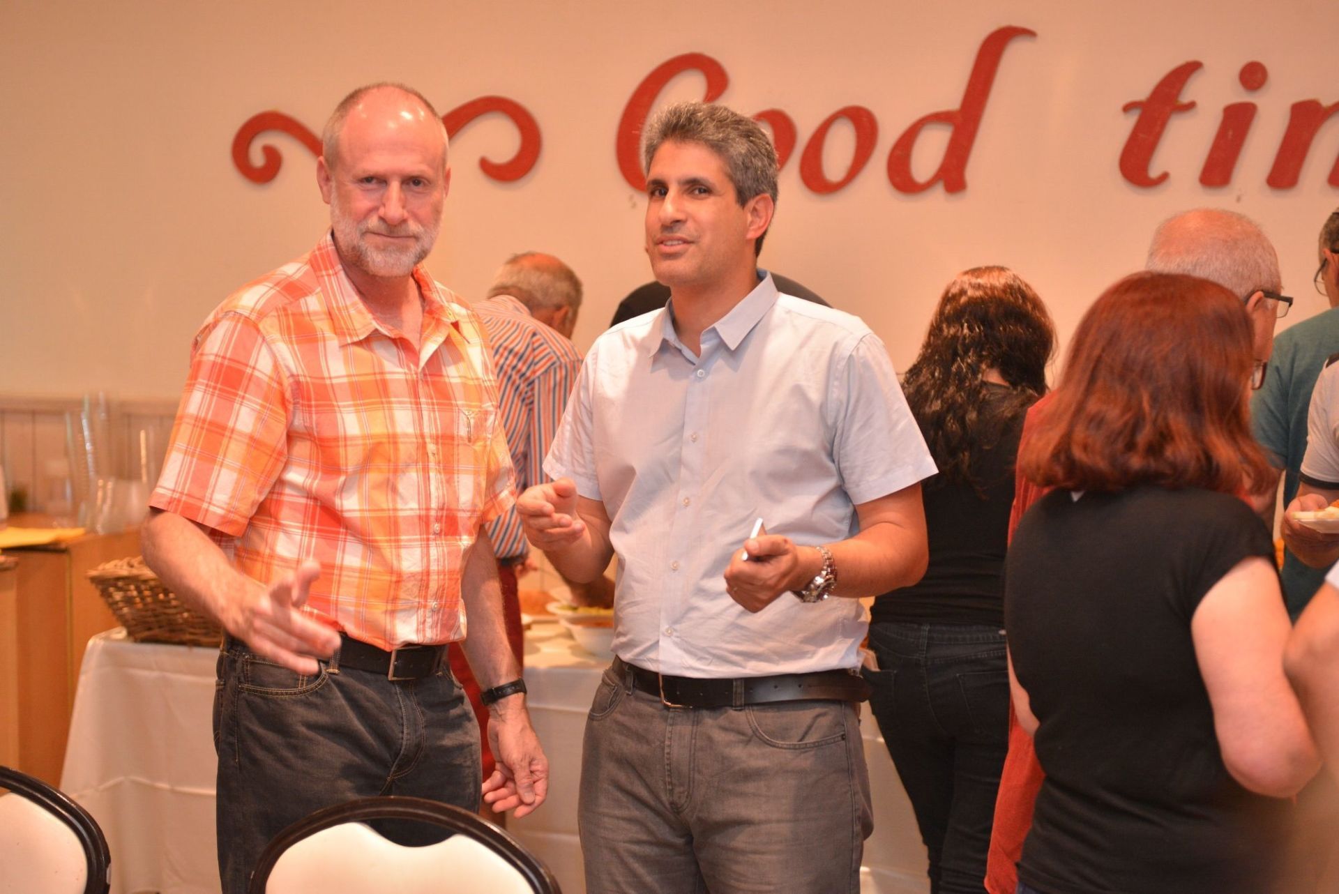 שני גברים עומדים מול קיר שאומר 