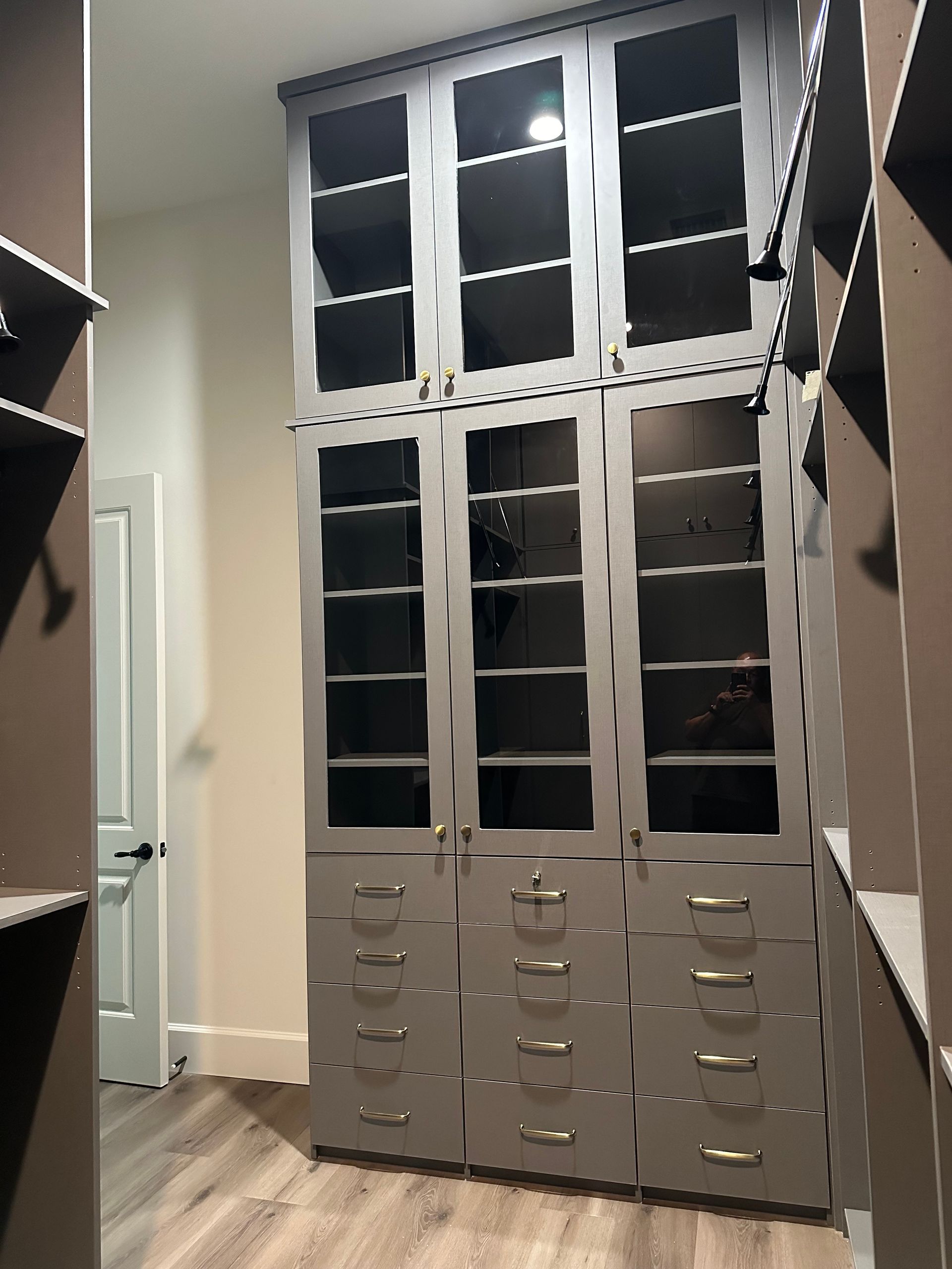A walk in closet with lots of drawers and cabinets