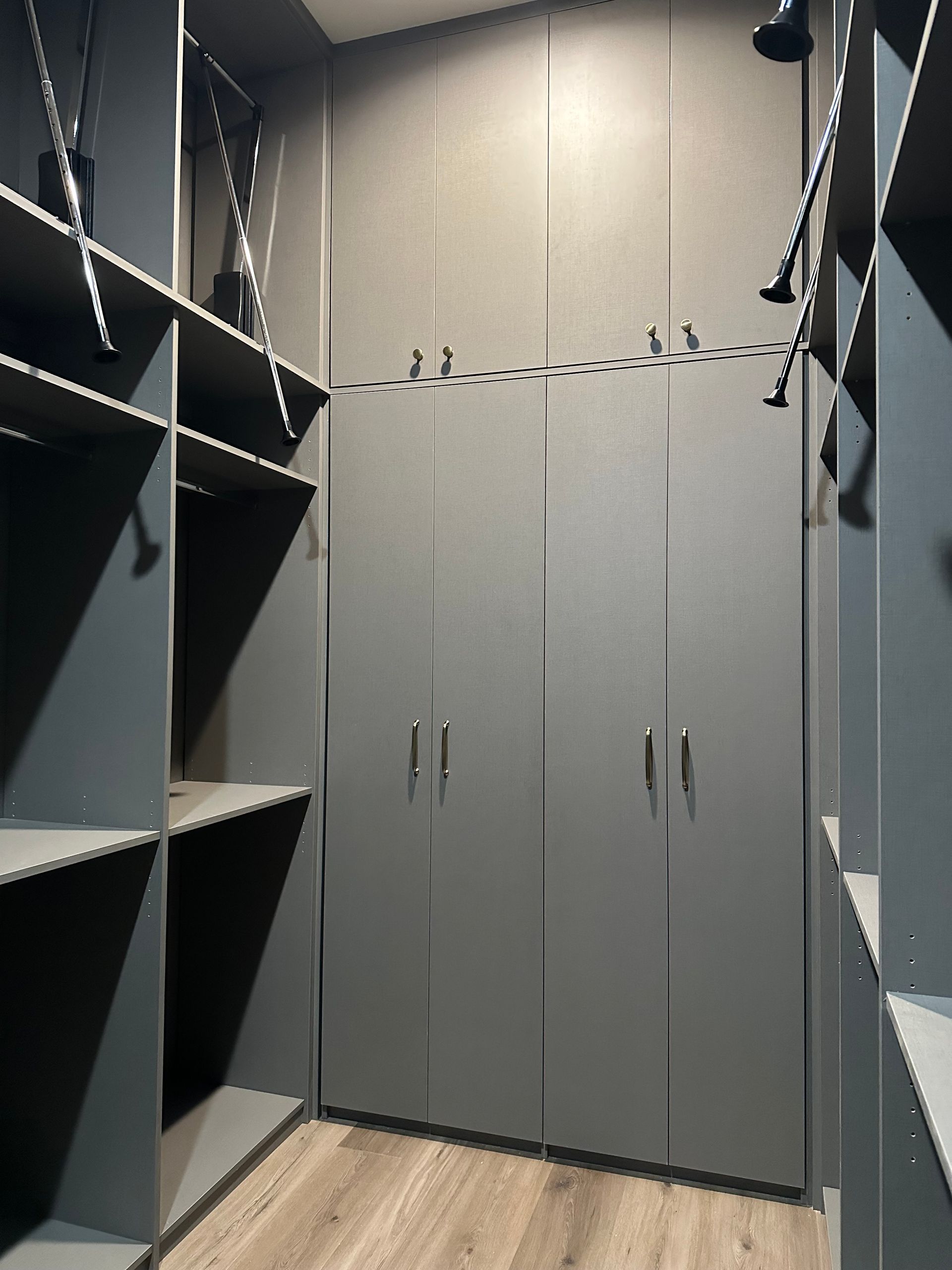 A walk in closet with a lot of shelves and cabinets