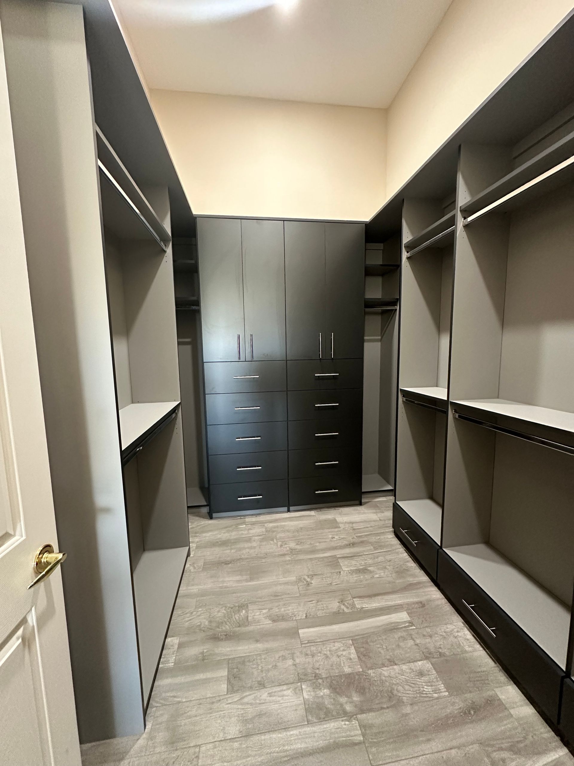 A walk in closet with lots of shelves and drawers.